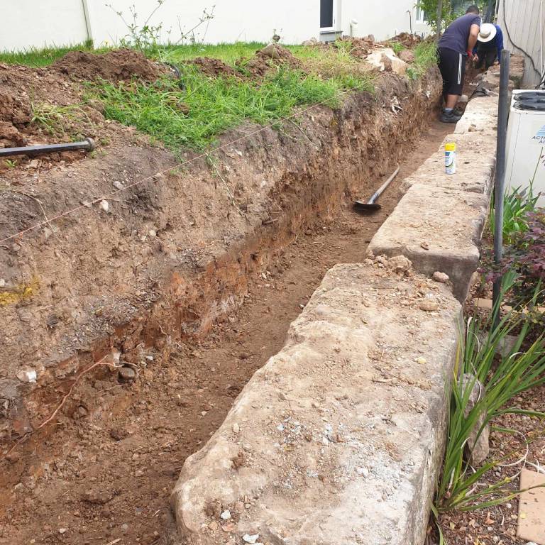 Excavation cut through a yard to correct the grade