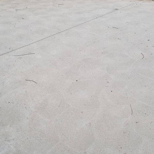 Grey hand-troweled concrete slab with an expansion joint