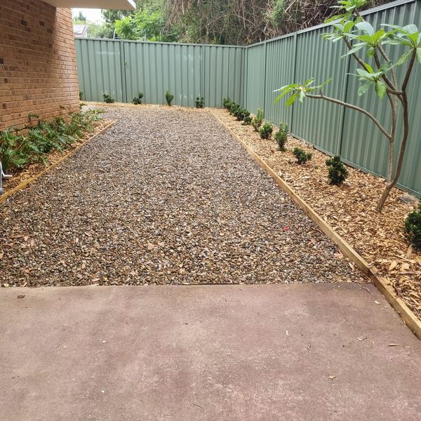 Gravel side path edged with timber and planted garden beds