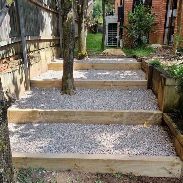Timber sleeper steps filled with gravel, stepping up around a tree