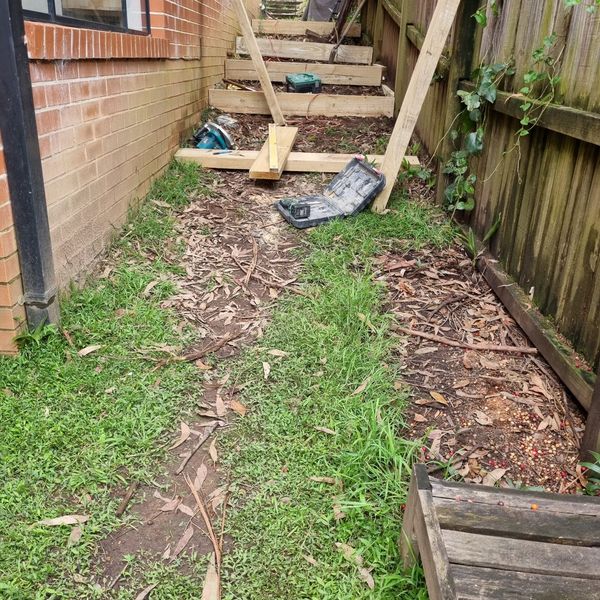 Bare side yard beside a brick house, cleared ready for landscaping