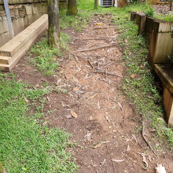 Sloping back yard stripped back and edged with timber sleepers