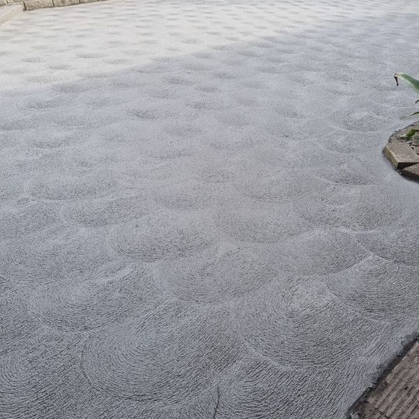 Broom-finished concrete driveway running up to a house