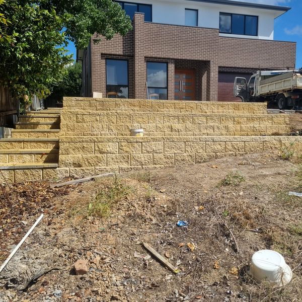 Terraced block retaining walls under construction with a tipper on site