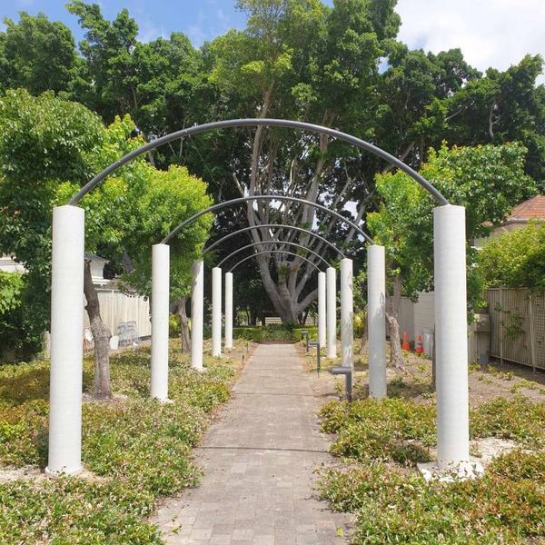 Steel pergola arches over a paved garden path