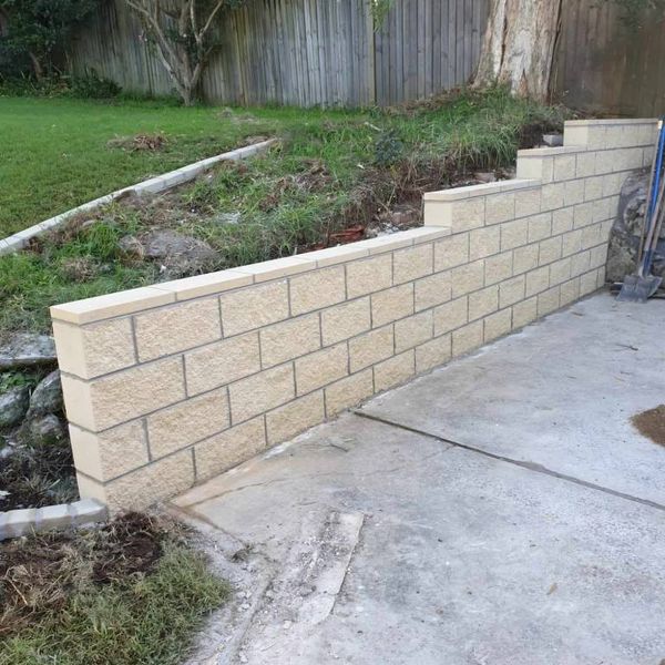 Block retaining wall finished against a new concrete slab