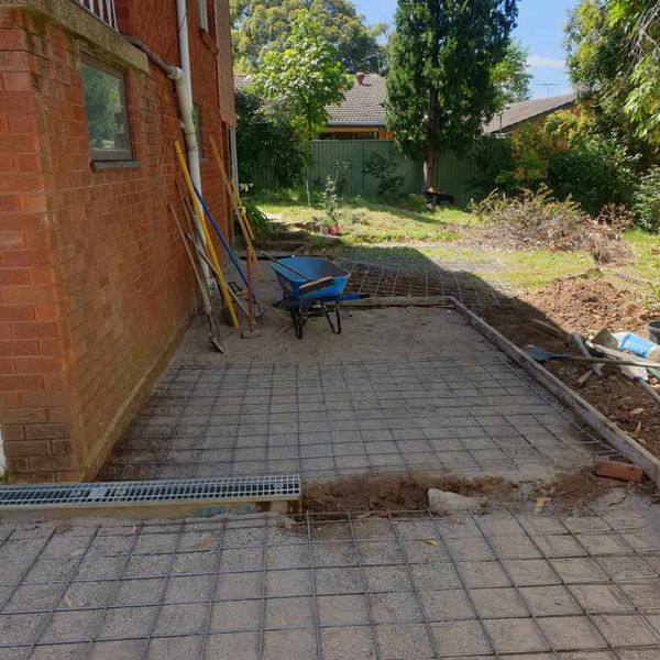 Paved courtyard with a drainage grate set along the house wall