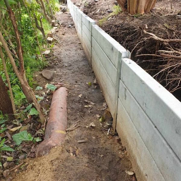 Concrete block retaining wall with excavated soil banked behind it
