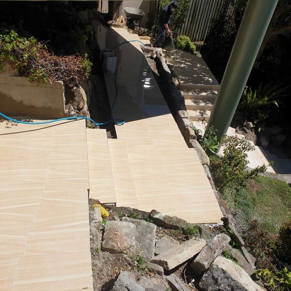 Tiled path and steps part-way through construction beside a rock face