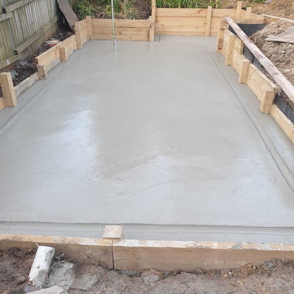 Freshly poured concrete slab sitting in its timber formwork