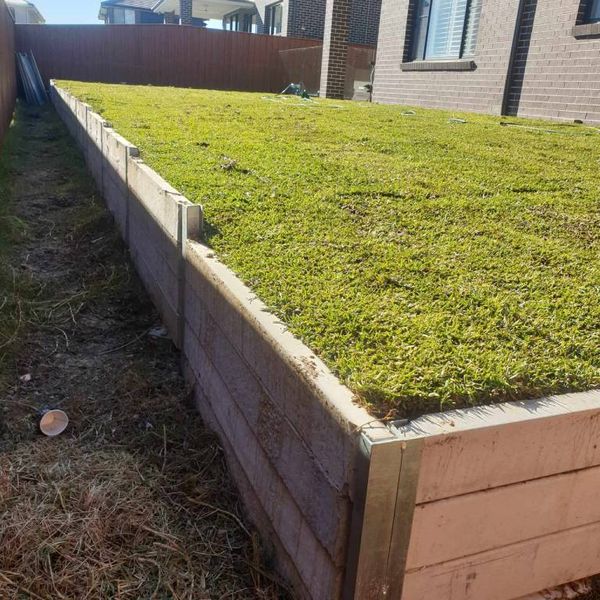 Raised timber sleeper bed topped with freshly laid turf