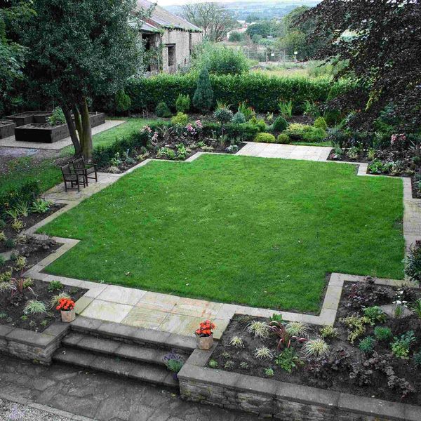 Formal lawn framed by a paved border and clipped hedging